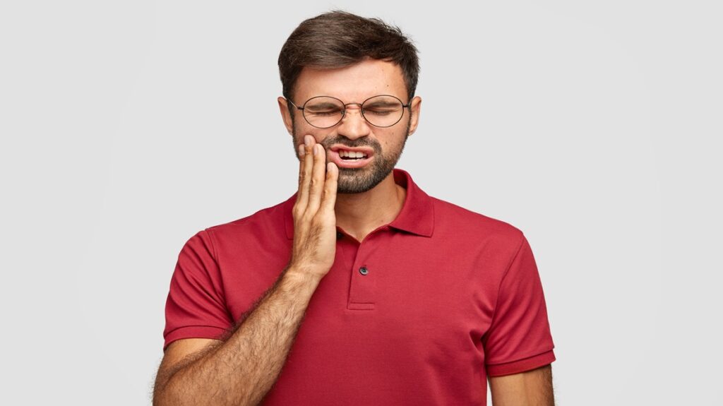 Homem sofrendo com dor por gengivite